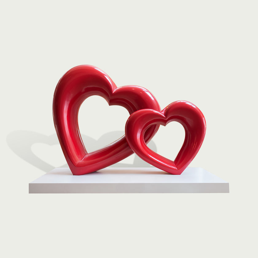 Interlocking Double Hearts Modern Abstract Sculpture Large Indoor Statues on a white rectangular pedestal against a light gray background.