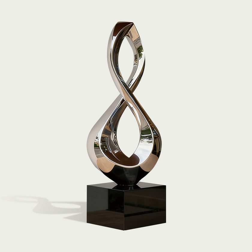 Gleaming Infinity Abstract Stainless Steel Sculpture on a glossy black rectangular base, set against a light gray background.