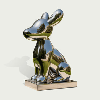 Adorable Cartoon Puppy Outdoor Stainless Steel Sculpture sitting on a rectangular metallic base, photographed against a plain light gray background.