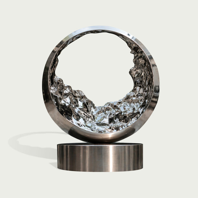 Mesmerizing Tidal Circle Abstract Stainless Steel Sculpture of a ring with a textured, liquid-like interior, mounted on a cylindrical base against a light gray background.