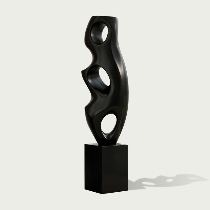 Abstract Large Voids Stainless Steel Sculpture with three circular cutouts, mounted on a rectangular black pedestal, set against a light gray background.
