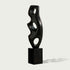Abstract Large Voids Stainless Steel Sculpture with three circular cutouts, mounted on a rectangular black pedestal, set against a light gray background.