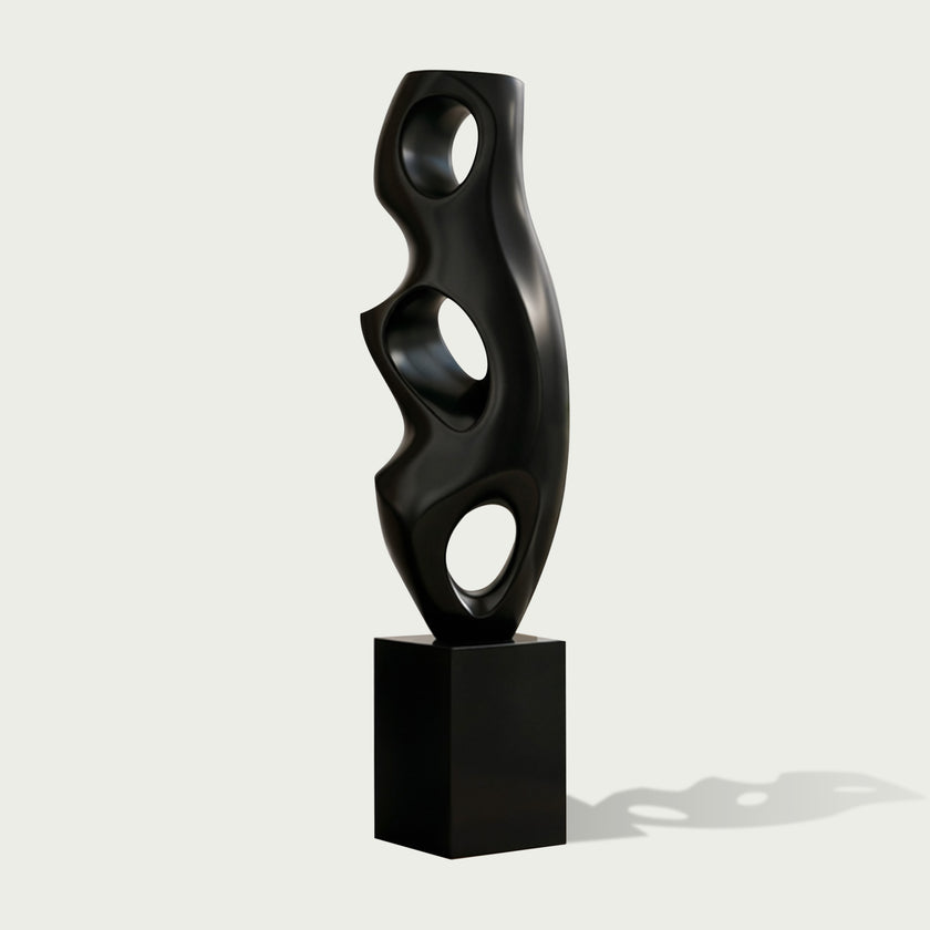 Abstract Large Voids Stainless Steel Sculpture with three circular cutouts, mounted on a rectangular black pedestal, set against a light gray background.