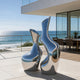 Flowing Vessel Organic Duo Stainless Steel Sculpture Large Outdoor Metal Artwork sculptures in a modern outdoor patio setting overlooking the ocean.