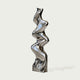 Vertical Liquid Ripple Abstract Stainless Steel Sculpture with a highly reflective, wavy metallic surface, standing on a square base against a light gray background.