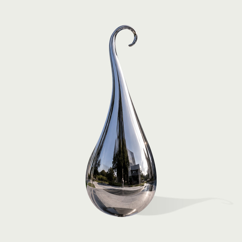 A teardrop-shaped polished chrome sculpture on a light gray background.