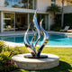 Polished Silver Seaweed Mirror Polished Metal Art Large Outdoor Sculpture by a poolside 