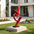 Sharp Angular Geometric Abstract Red Stainless Steel Sculpture on a lawn