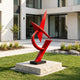 Sharp Angular Geometric Abstract Red Stainless Steel Sculpture on a lawn