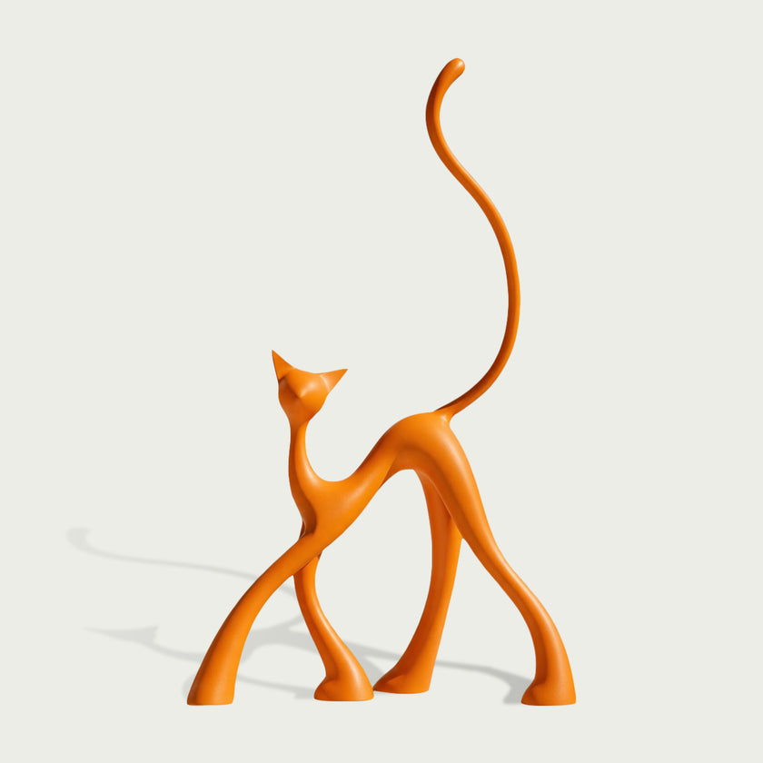 An abstract orange cat sculpture with a long curved tail, standing on a light gray background with a soft shadow.