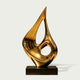 Hollow Golden Flame Drop Stainless Steel Sculpture on a white background