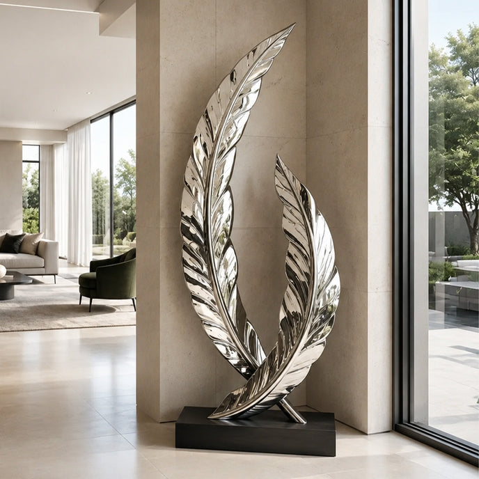 A mirror-polished stainless steel sculpture of two intersecting curved feathers on a black base. Displayed in a luxury hallway, this reflective metal art piece elevates modern indoor decor.