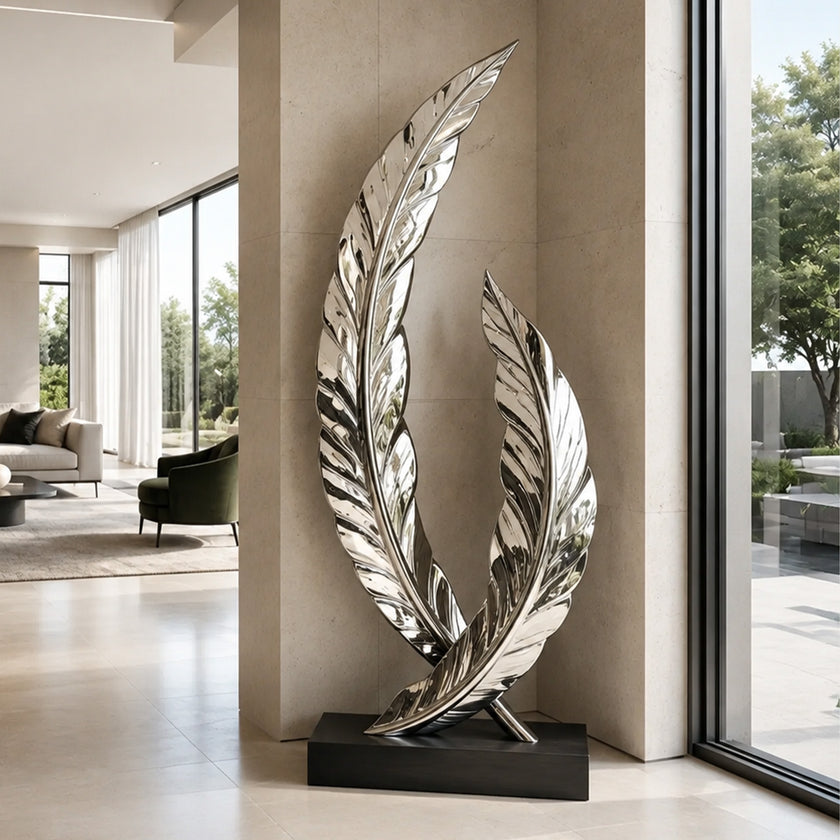 A mirror-polished stainless steel sculpture of two intersecting curved feathers on a black base. Displayed in a luxury hallway, this reflective metal art piece elevates modern indoor decor.