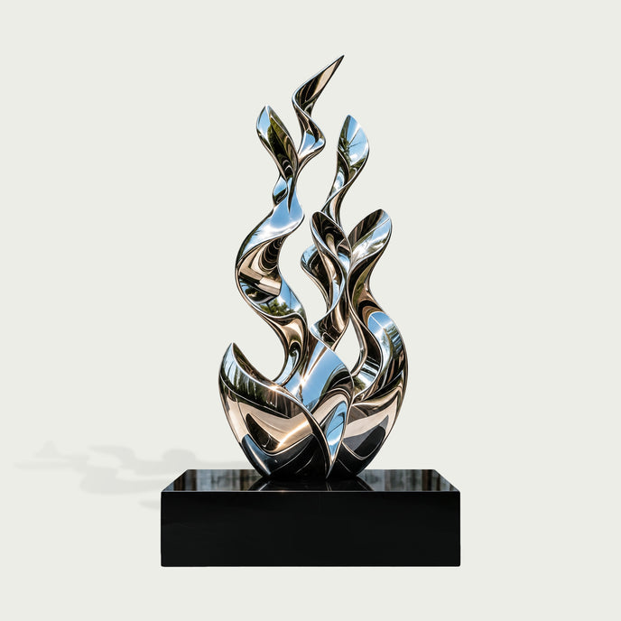 Contemporary abstract stainless steel sculpture featuring multiple tall, twisting ribbon-like forms that rise organically from an intertwined sculptural base. The elegant composition combines flowing curves, leaf-shaped pointed tips, and open spaces to create a dynamic sense of upward movement. Its highly reflective mirror-polished silver surface captures distorted reflections of trees, blue sky, and surrounding architecture. Displayed on a rectangular glossy black pedestal against a clean light background,