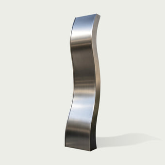 A minimalist curved stainless steel sculpture with a smooth wave-like form and brushed metal surface. The modern water feature artwork showcases elegant lines for contemporary outdoor design.