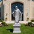Large white granite Jesus Christ statue with open arms displayed in front of a church entrance, showcasing detailed robe folds and sacred architectural decor